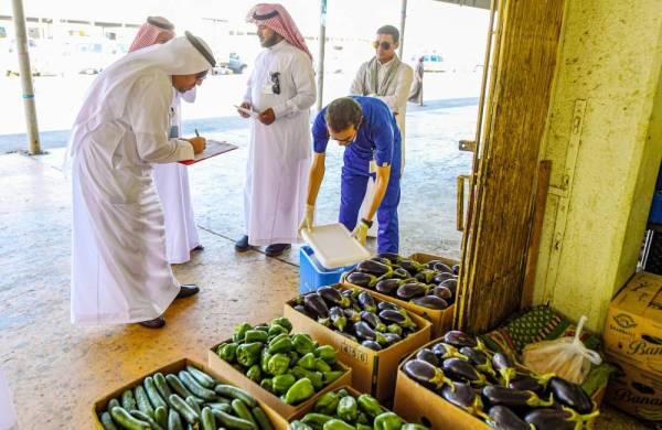 



فحص الفواكه والخضراوات المعروضة في السوق المركزية.