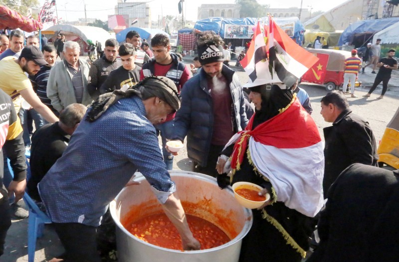 



عراقي يقدم الطعام للمتظاهرين الذين تجمعوا في ميدان التحرير ببغداد أمس. (أ ف ب)