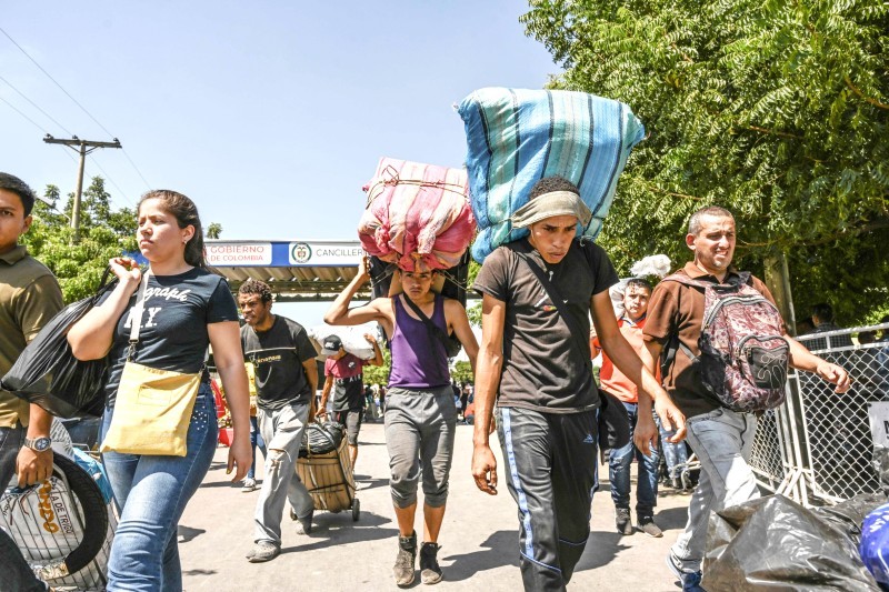 Venezuelan people cross the Simon Bolivar International Bridge back to Venezuela, after buying supplies in Cucuta, Norte de Santander, Colombia, on January 4, 2020. / AFP / Juan BARRETO
