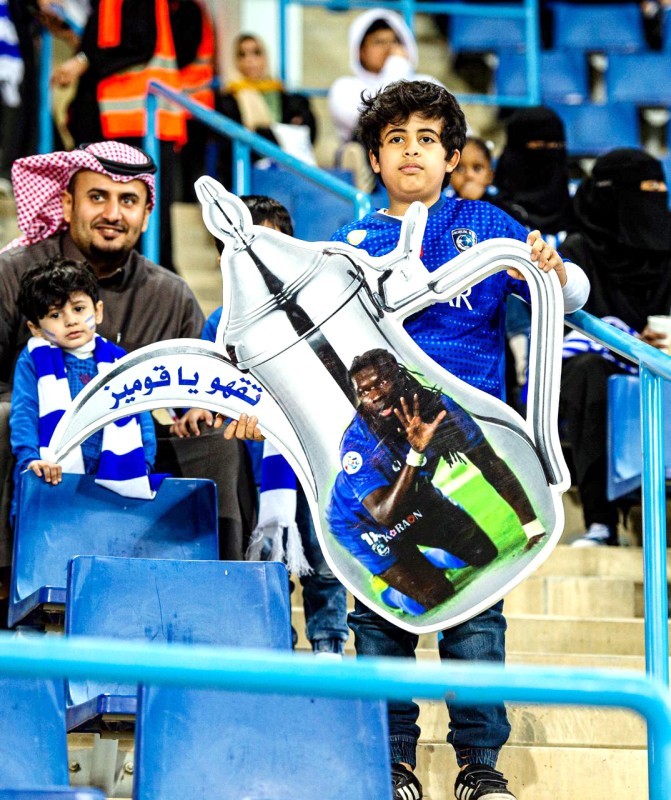  الطفل رائد بن نادر يحمل مجسم الدلة في مدرجات نادي الهلال. (تصوير: عبدالعزيز السلامة)