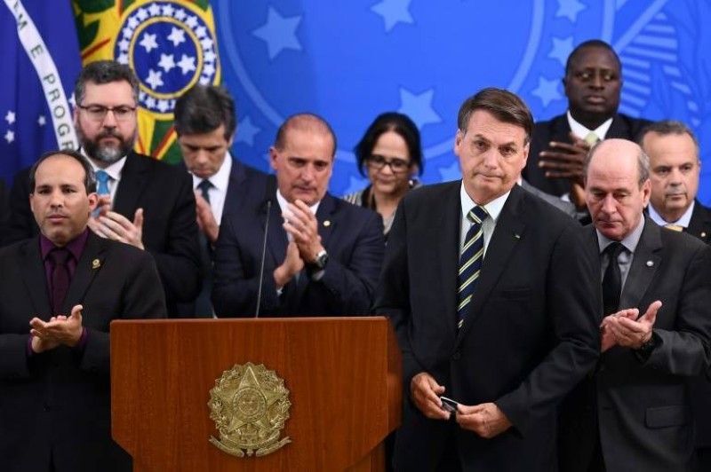 الرئيس البرازيلي جاير بولسونارو في مؤتمر صحافي في برازيليا وحوله أعضاء الحكومة (أ.ف.ب.)