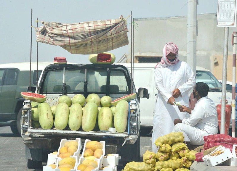 شابان من أبناء الوطن لم ينتظرا الوظيفة، بل تحركا للضرب في الأرض واستخراج الخير منها بمتعة وهمة، ببيع الفواكه والخضار في موقع حيوي في جدة. (تصوير: عبدالسلام السلمي)