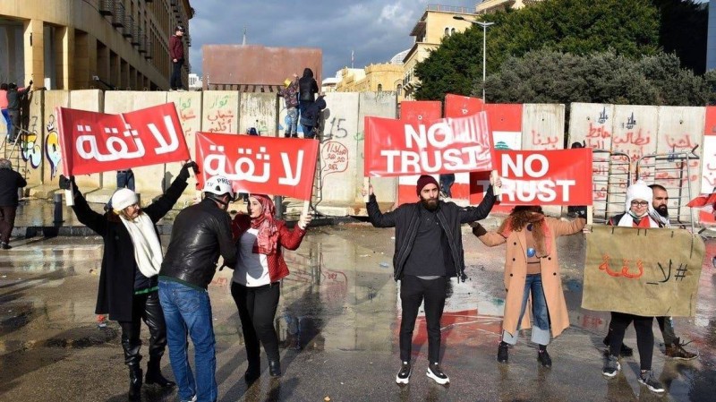 



محتجون لبنانيون يرفعون لافتات تؤكد عدم ثقتهم في السلطة الحاكمة خلال مظاهرات سابقة.