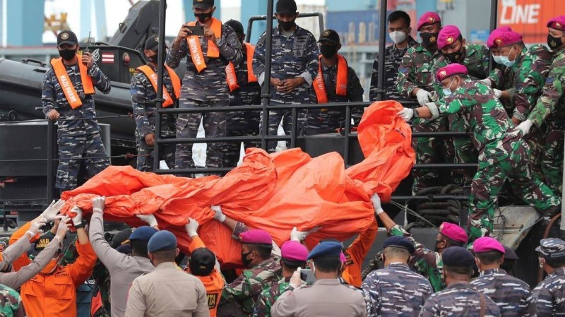 فريق البحث الإندونيسي ينتشل جثة من الطائرة المنكوبة.