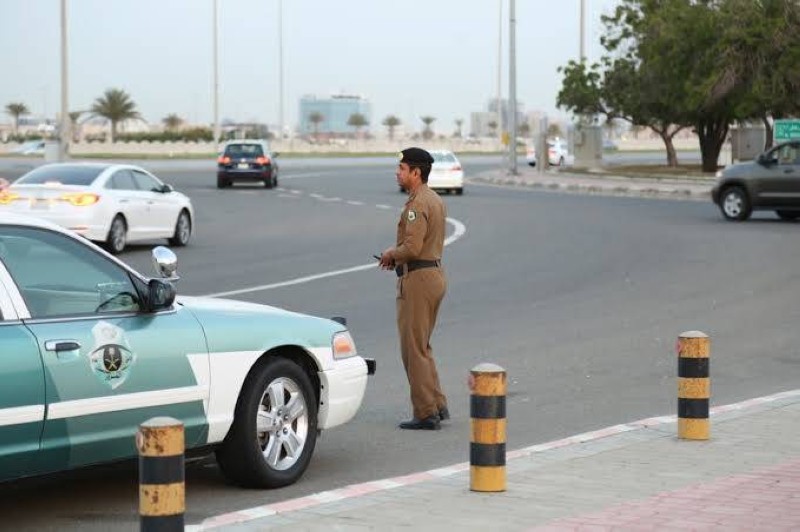 رجل مرور يراقب الحركة المرورية لضبط السير.