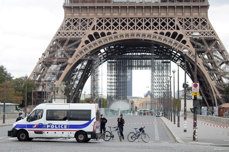 French police stand near the Eiffel Tower after the French tourism landmark was evacuated following a bomb alert in Paris, France, September 23, 2020. REUTERS/Charles Platiau