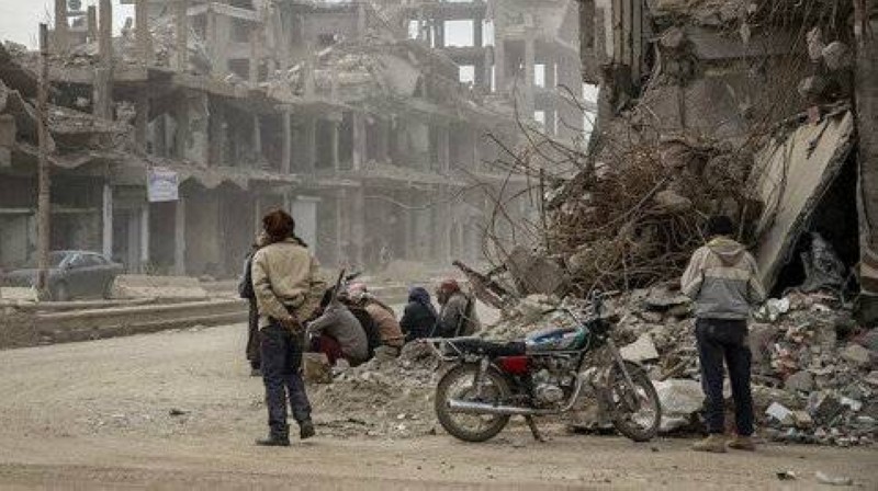 اطفال سوريون يلهون أمام مباني مدمرة