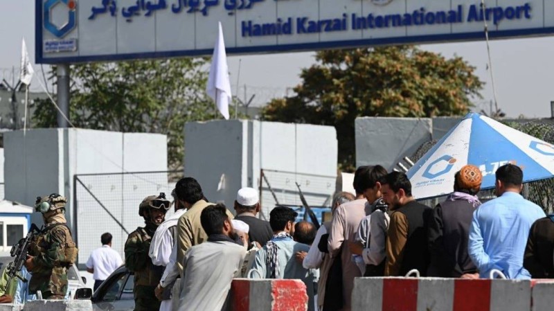  أفغانيون ينتظرون أمام مطار حامد كارزاي الدولي.