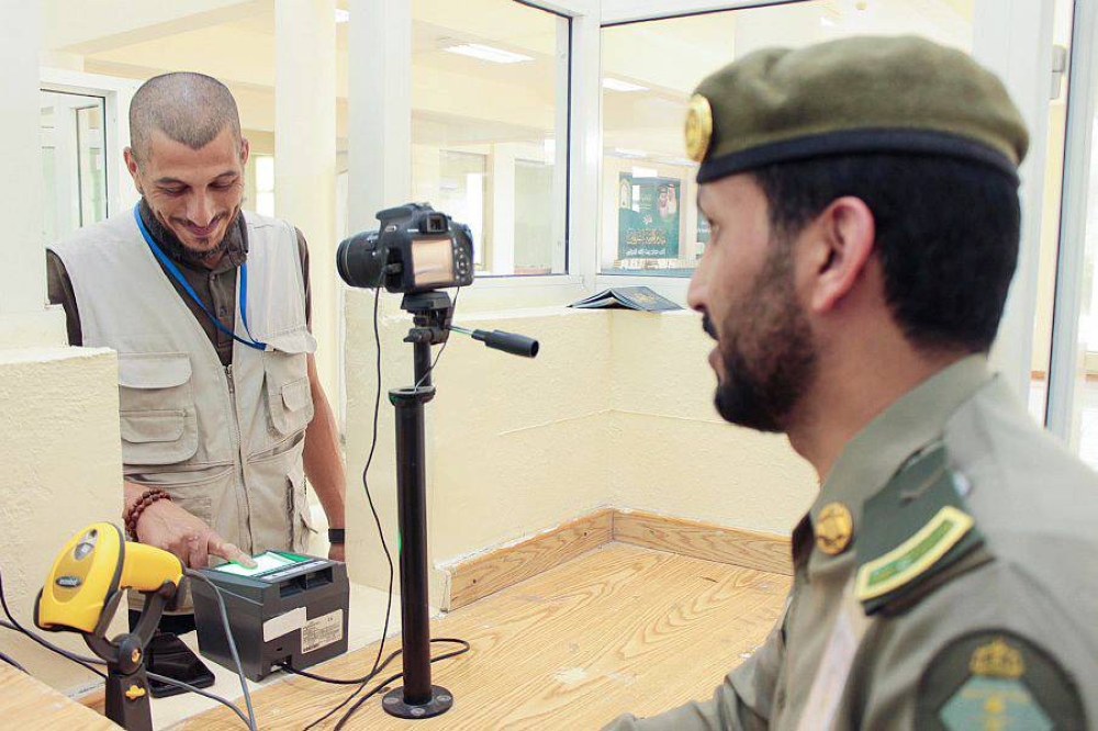 



حاج بمنفذ حالة عمار يتحدث لموظف الجوازات أثناء إنهاء إجراءات مغادرته المملكة. (واس)