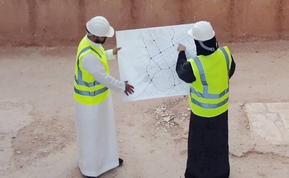 مهندسان سعوديان يطالعان خريطة لموقع للتأكد من سلامة التنفيذ. (هيئة المهندسين)