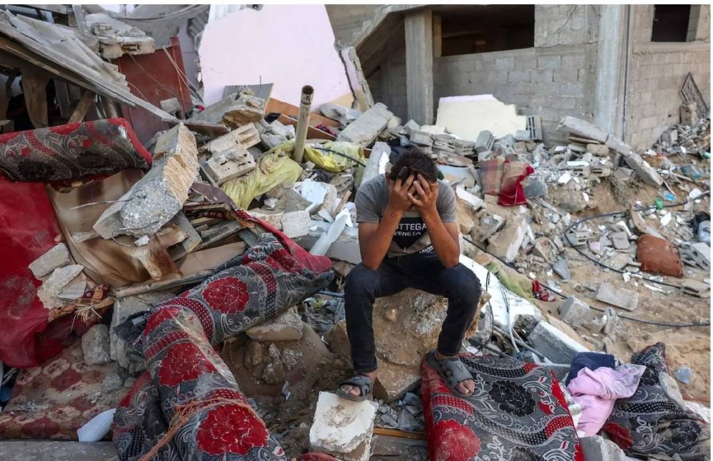 فلسطيني يبكي على أنقاض منزله الذي دمره العدوان الإسرائيلي.
