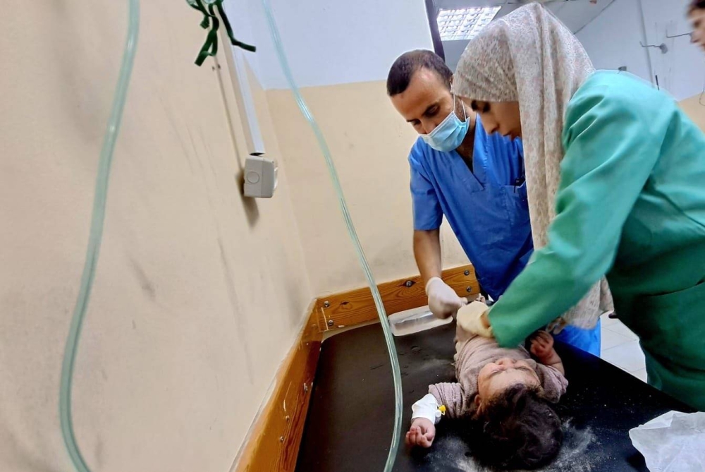 أطباء يحاولون إنقاذ طفلة مصابة جراء القصف الإسرائيلي العنيف على الأحياء في غزة اليوم. (وكالات فلسطينية)