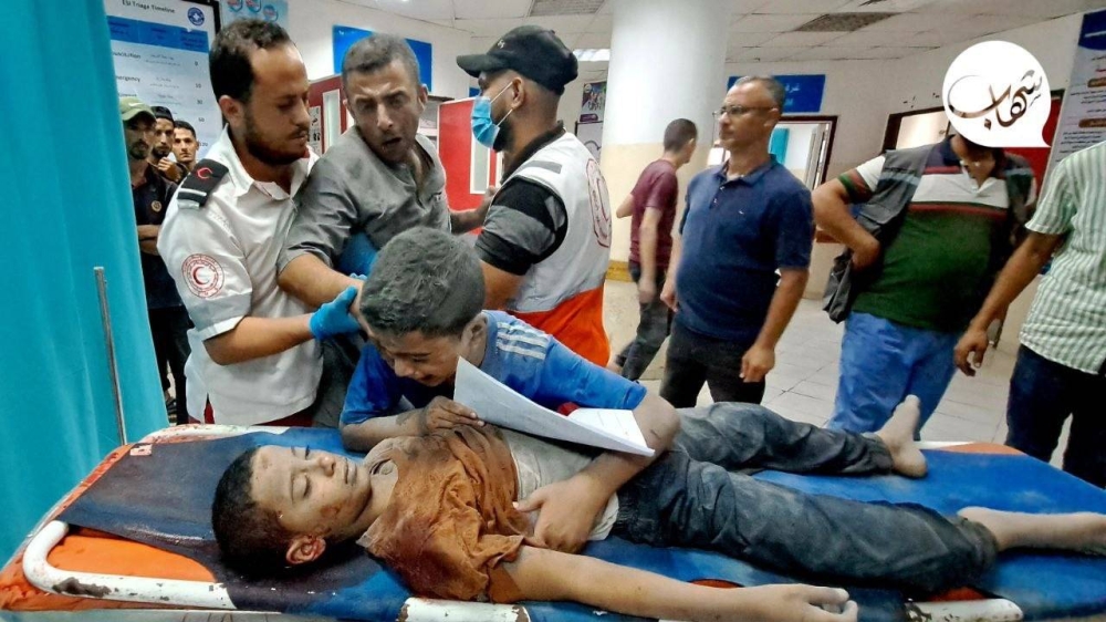 طفل يودع شقيقه الذي قُتل جراء قصف إسرائيل منزلهما في غزة اليوم. (وكالات فلسطينية)