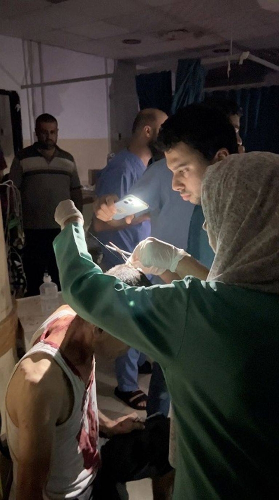 طبيبة تعالج طفلة مصابة على ضوء الموبايل بأحد مستشفيات غزة.