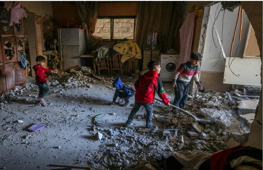 أطفال فلسطينيون داخل منزلهم الذي دمره الاحتلال الإسرائيلي.