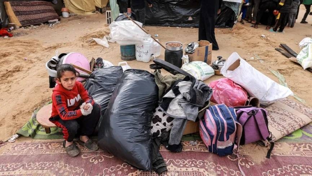 طفلة فلسطينية نازحة أمام خيمة في رفح جنوب غزة بجوار ما تبقى من أمتعة عائلتها