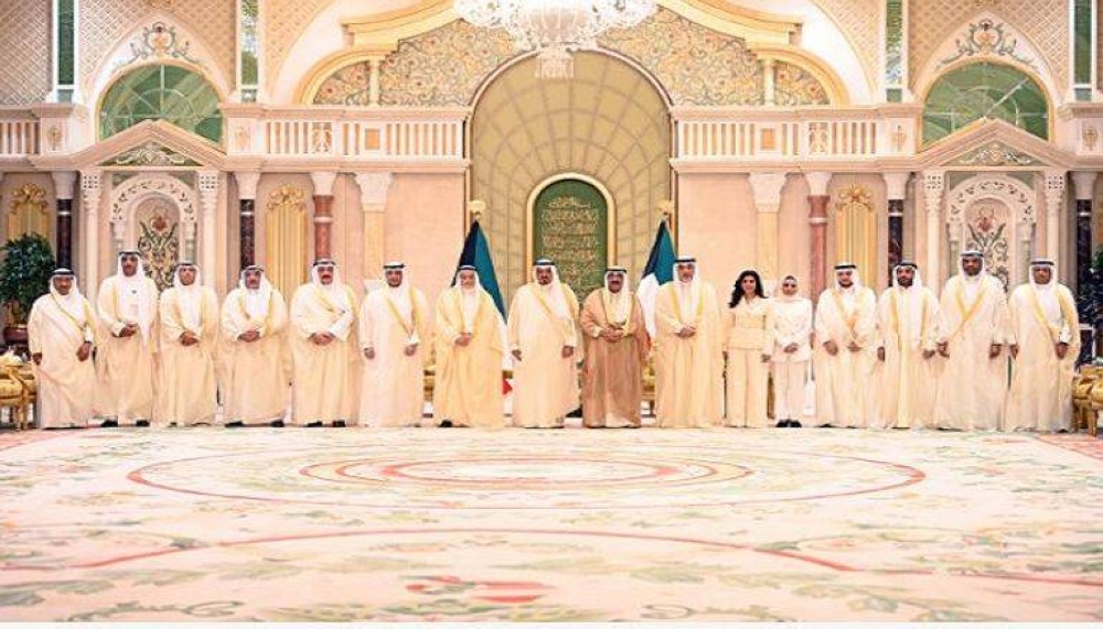  أمير الكويت يتوسط أعضاء الحكومة الجديدة بعد أداء اليمين الدستورية.