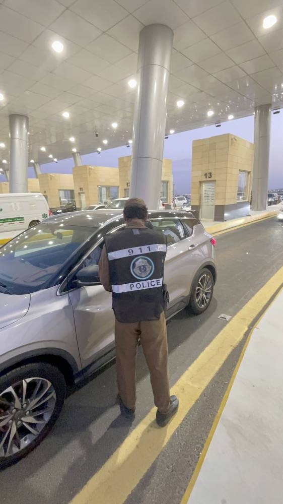 



رجل أمن يتأكد من تصريح سائق مركبة أثناء الدخول إلى مكة المكرمة.