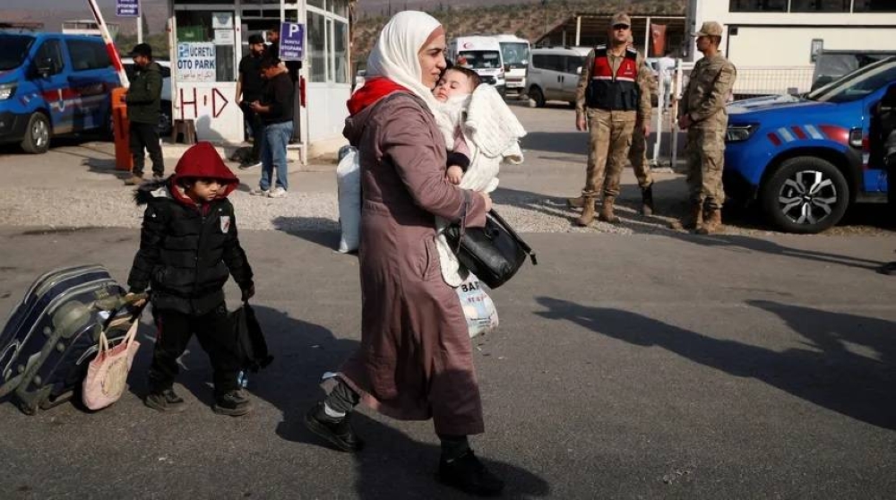 سورية تحمل طفلها وهي في طريقها إلى بلادها عبر معبر شيلفيغوزو قادمة من تركيا