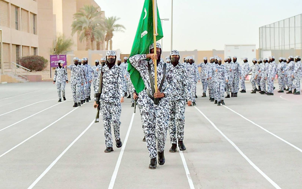 



مجنّدة بمعهد التدريب الأمني النسائي تتقدّم مسيرة مشروع «السير الطويل» حاملة علم المملكة.